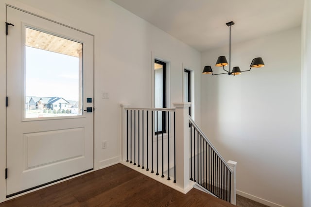 doorway to outside featuring a notable chandelier and dark hardwood / wood-style floors