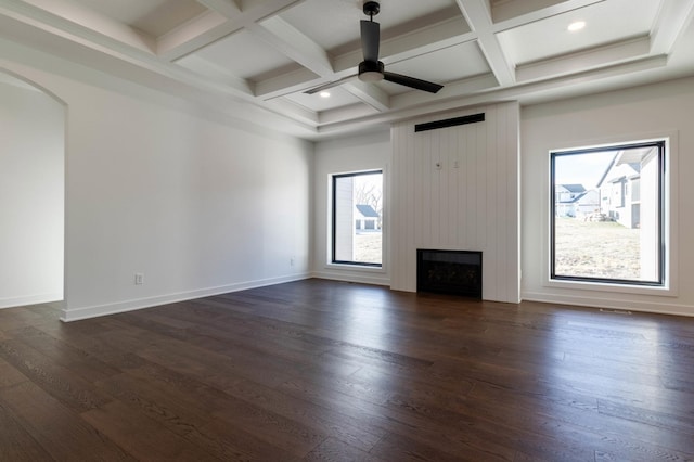 unfurnished living room with beam ceiling, ceiling fan, coffered ceiling, dark hardwood / wood-style floors, and a fireplace