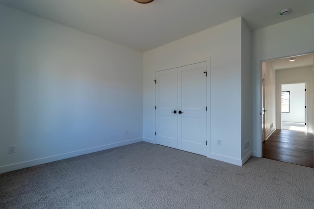 unfurnished bedroom featuring carpet floors and a closet