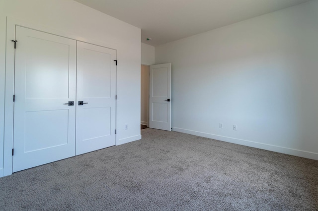 unfurnished bedroom with carpet flooring and a closet