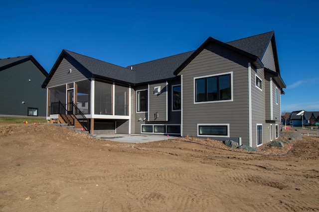 rear view of property featuring a sunroom