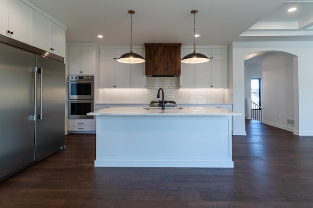 3180 Bella Terra Ln NE, Rochester, MN 55906 - kitchen featuring appliances with stainless steel finishes, arched walkways, backsplash, white cabinetry, and recessed lighting
