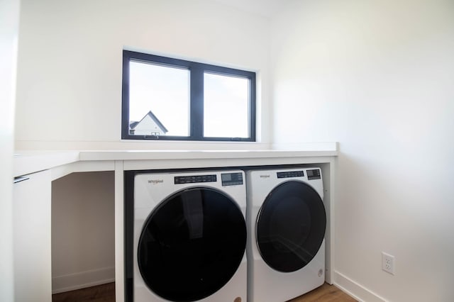 laundry area featuring hardwood / wood-style flooring and washing machine and clothes dryer