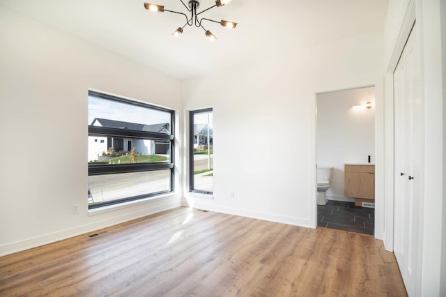 unfurnished room featuring dark hardwood / wood-style flooring and a chandelier