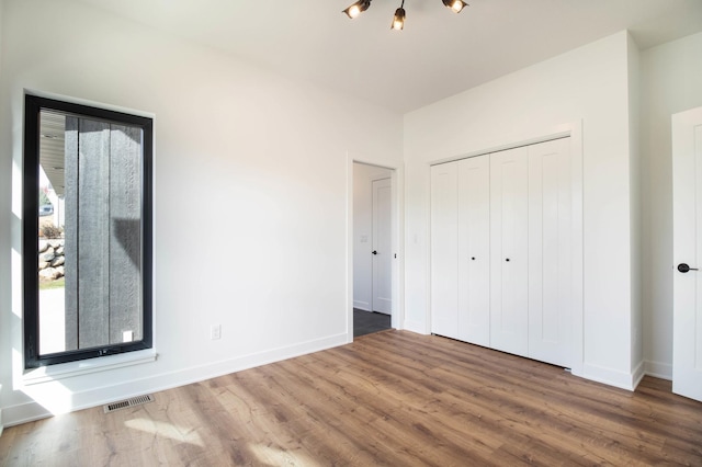 unfurnished bedroom featuring a closet and hardwood / wood-style floors