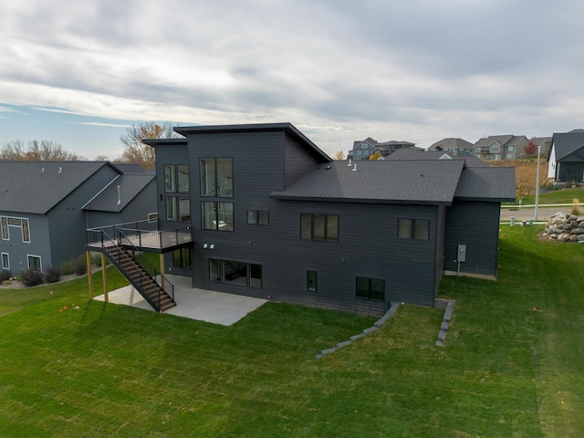 rear view of house with a patio area, a deck, and a lawn