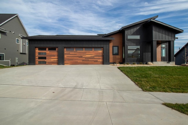 contemporary home featuring a garage and a front lawn