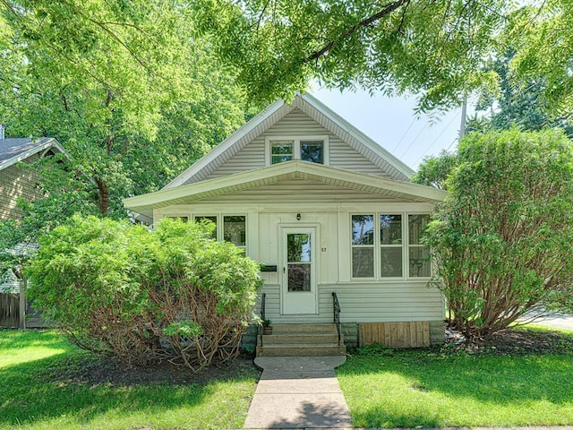 bungalow-style home with a front yard