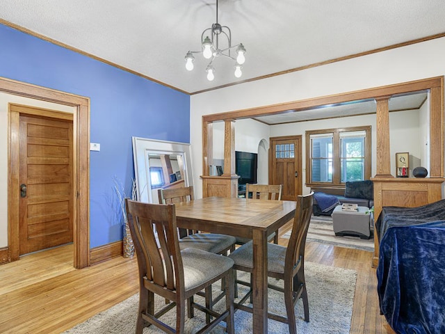 dining room featuring crown molding, wood-type flooring, and a chandelier