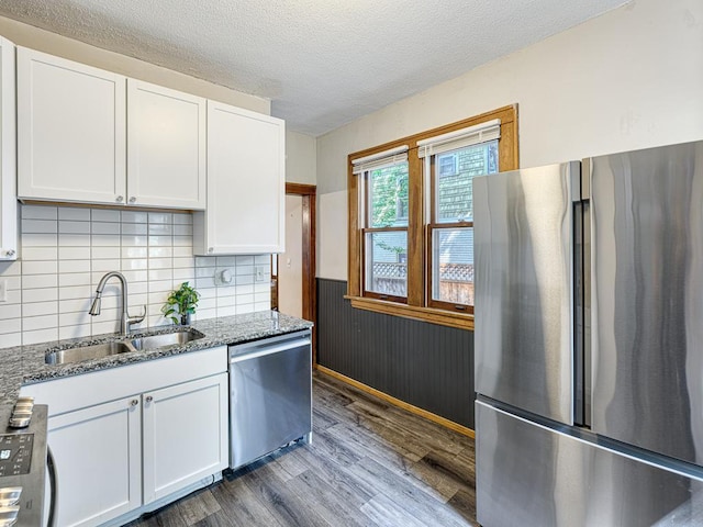 kitchen featuring appliances with stainless steel finishes, stone countertops, sink, and white cabinets