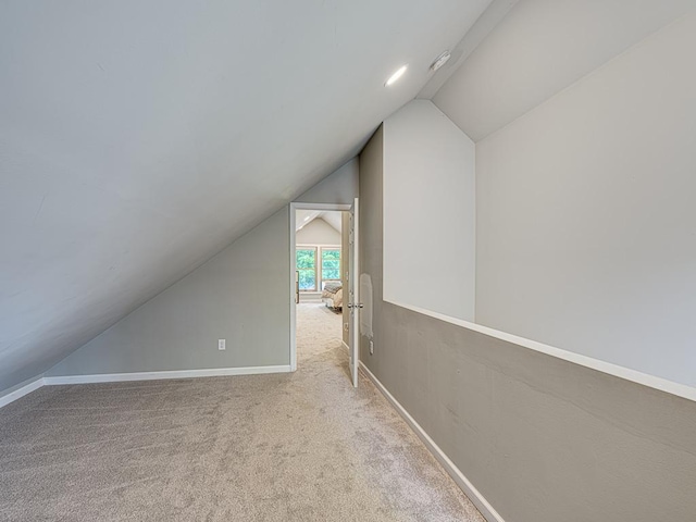 bonus room featuring lofted ceiling and light colored carpet