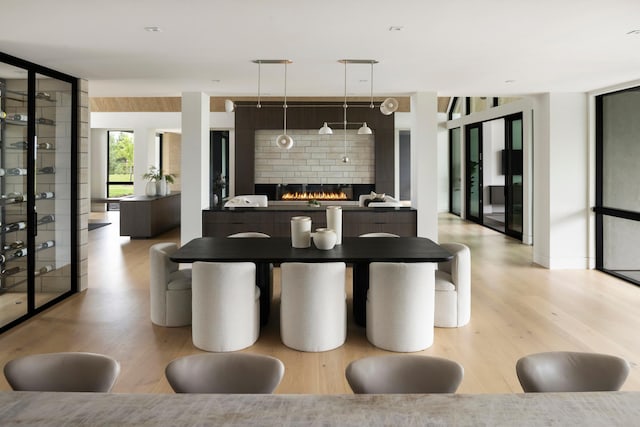 dining space featuring a fireplace and light hardwood / wood-style flooring