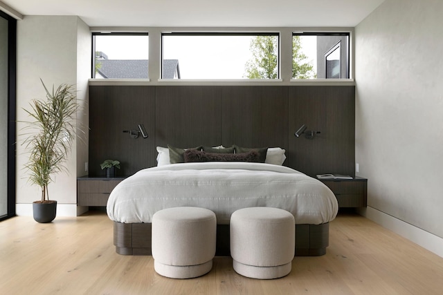 bedroom featuring light hardwood / wood-style flooring and multiple windows