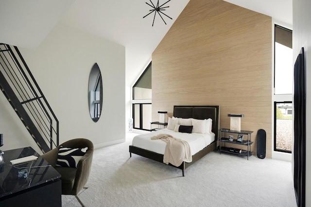 carpeted bedroom with high vaulted ceiling and wood walls