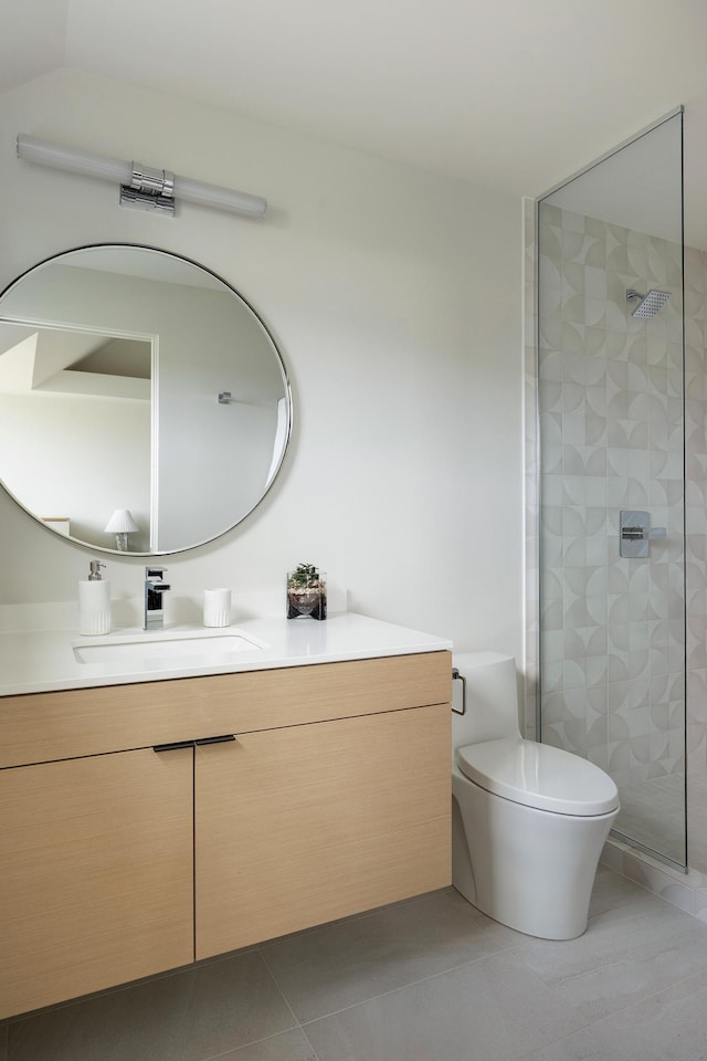 bathroom featuring tile patterned flooring, vanity, toilet, and tiled shower