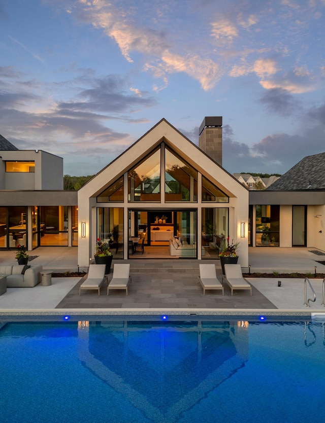 pool at dusk featuring a patio area