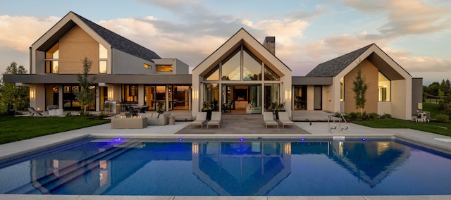 back house at dusk with an outdoor hangout area and a patio