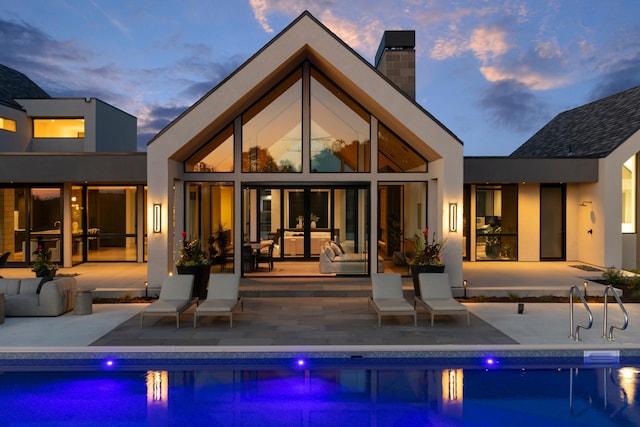 back house at dusk with a patio area