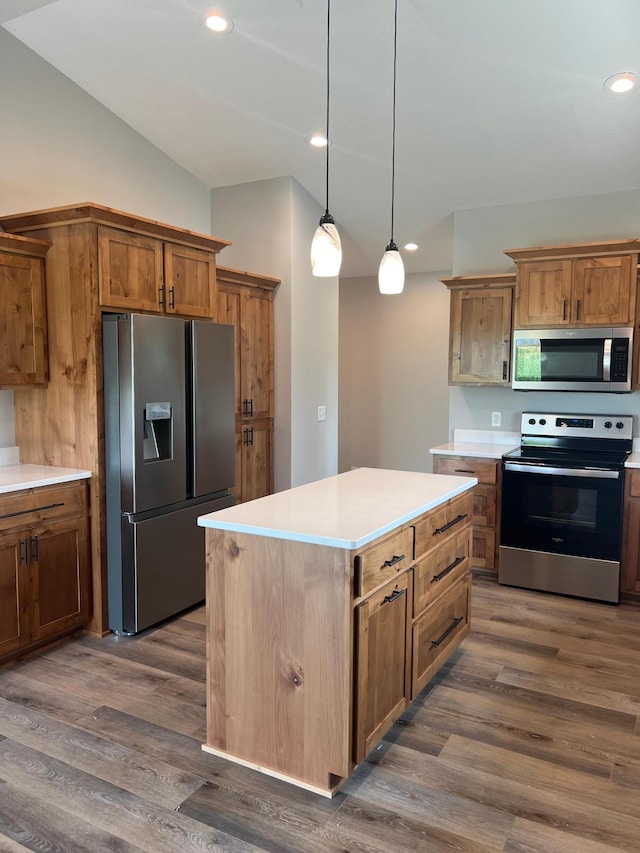 kitchen with dark wood-type flooring, stainless steel appliances, a kitchen island, decorative light fixtures, and vaulted ceiling