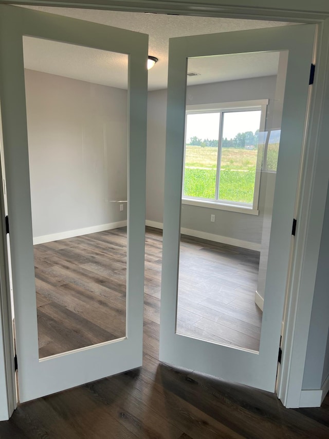 spare room with dark hardwood / wood-style flooring and a textured ceiling