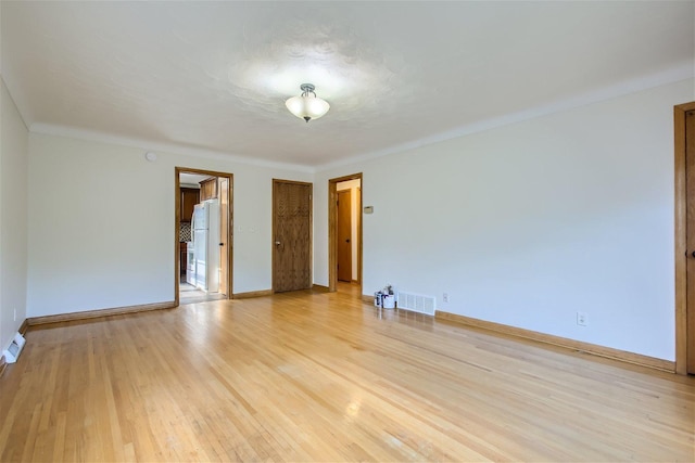 unfurnished room featuring crown molding and light hardwood / wood-style flooring