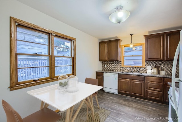 kitchen with dishwasher, hanging light fixtures, dark hardwood / wood-style flooring, sink, and decorative backsplash