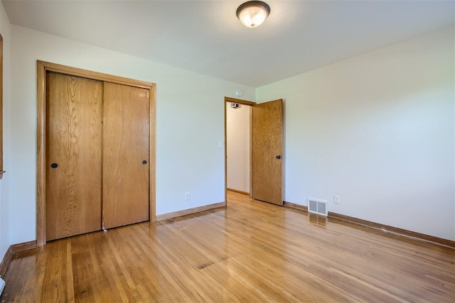 unfurnished bedroom featuring a closet and light hardwood / wood-style flooring