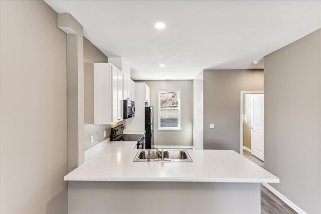 kitchen featuring white cabinets, kitchen peninsula, sink, and range with electric stovetop