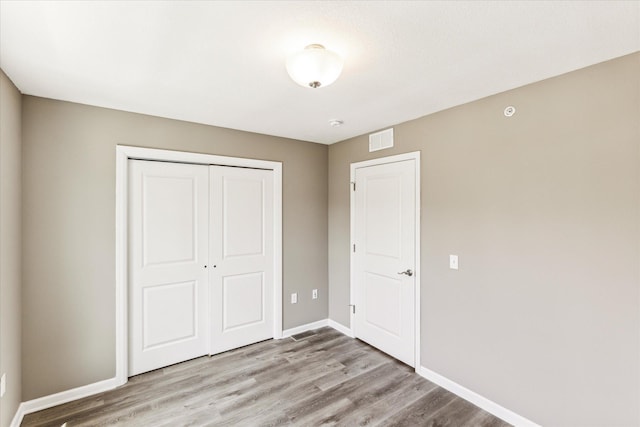 unfurnished bedroom with light hardwood / wood-style floors and a closet