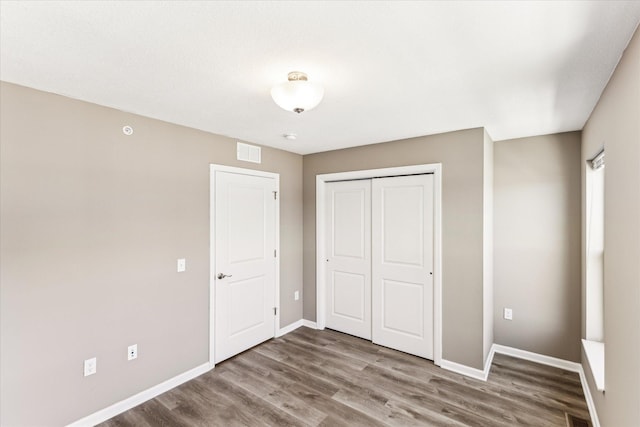 unfurnished bedroom with hardwood / wood-style flooring and a closet