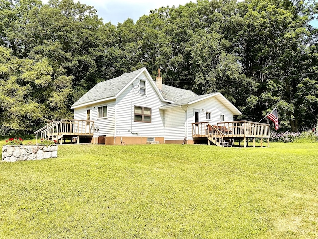 exterior space with a wooden deck, a chimney, roof with shingles, and a yard