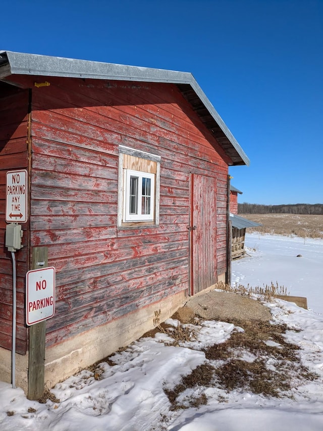 view of snowy exterior featuring an outdoor structure