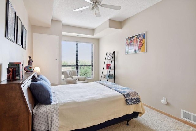 bedroom featuring a textured ceiling, ceiling fan, carpet floors, visible vents, and baseboards