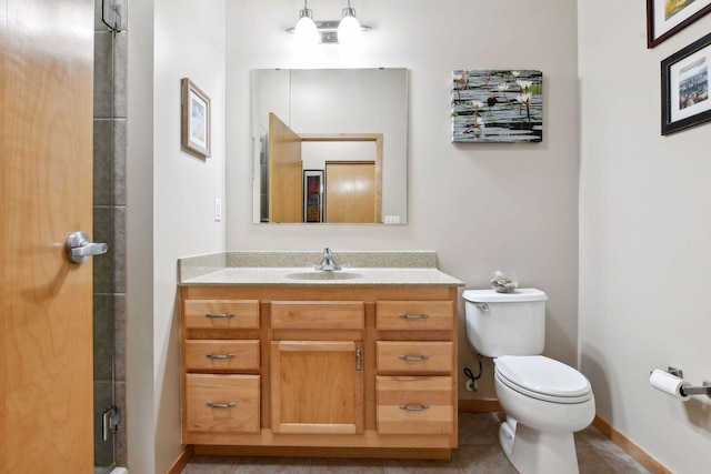 bathroom with toilet, an enclosed shower, vanity, tile patterned flooring, and baseboards