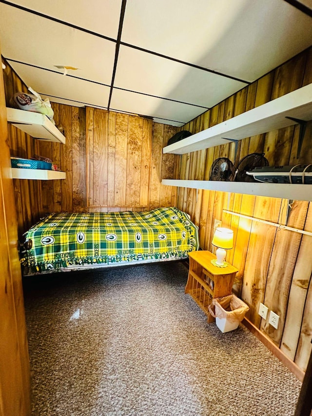 unfurnished bedroom featuring carpet floors and wood walls