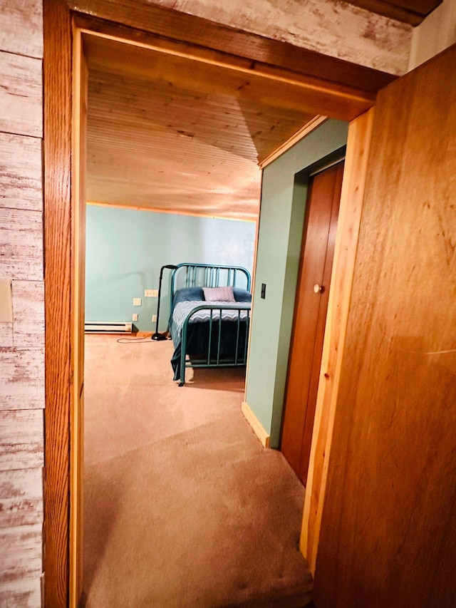 corridor with baseboard heating, wood ceiling, and carpet floors