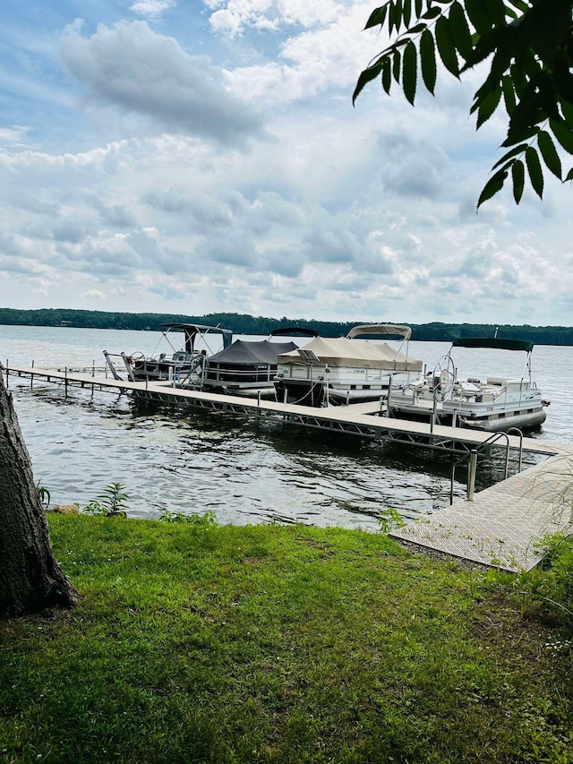 dock area with a water view and a lawn