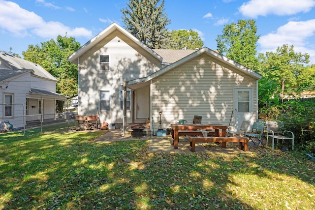 rear view of house featuring a patio and a yard