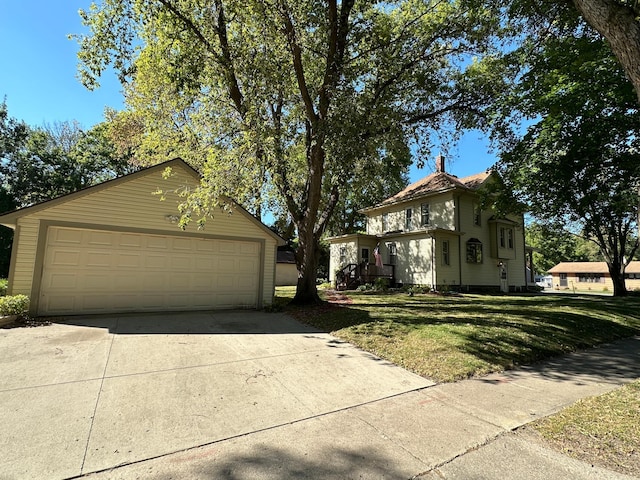 view of front facade with a front yard and a detached garage