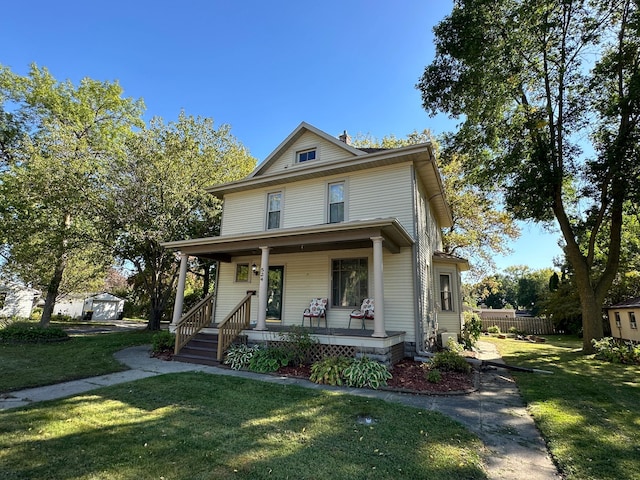 traditional style home with covered porch and a front lawn