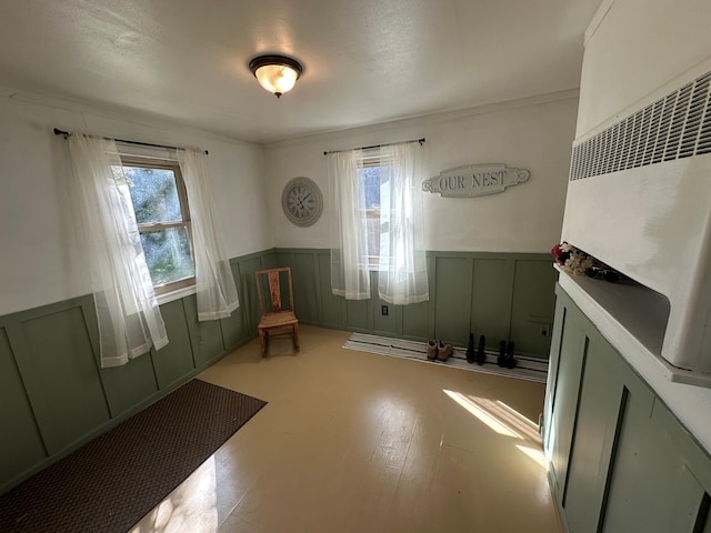 sitting room featuring a wainscoted wall, light wood-type flooring, and a decorative wall