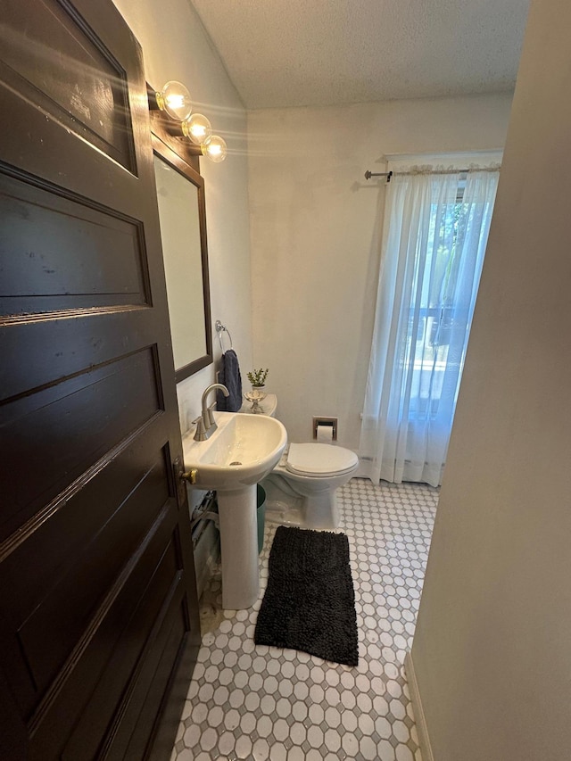 bathroom featuring a textured ceiling and toilet