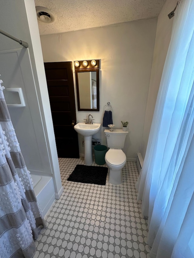 full bathroom featuring baseboards, toilet, a baseboard radiator, shower / bath combination with curtain, and a textured ceiling