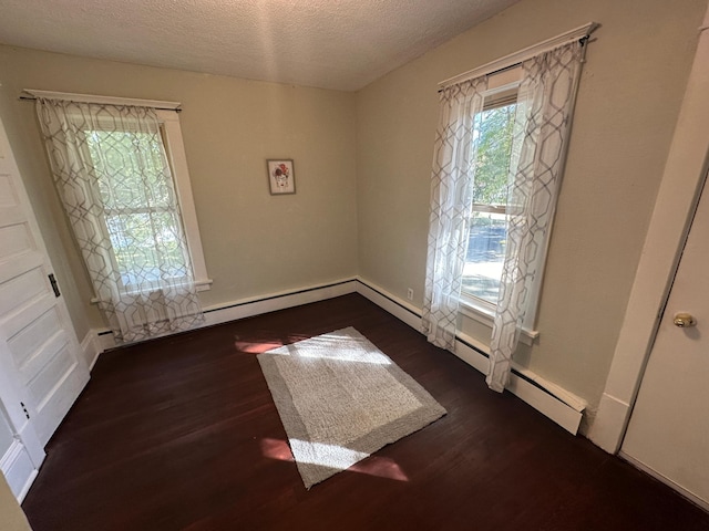 unfurnished room featuring dark wood-type flooring and a textured ceiling