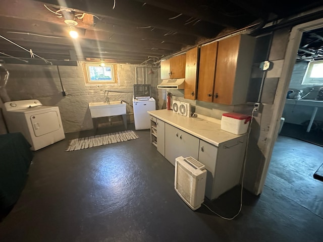 below grade area with a sink and washer and clothes dryer