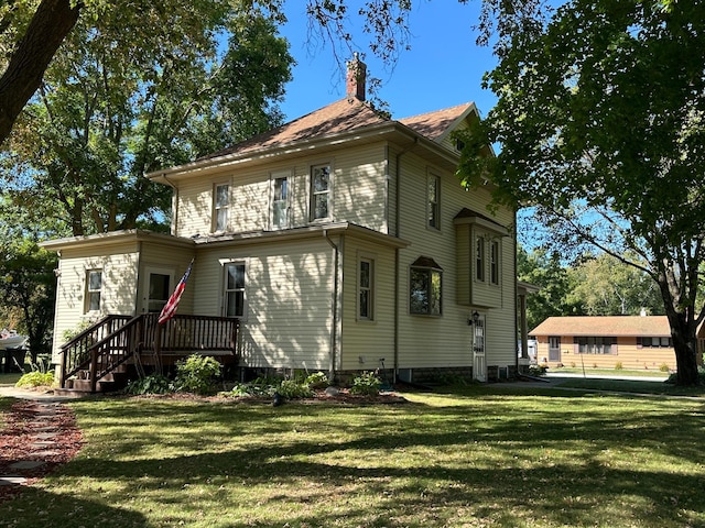 rear view of property with a yard and a chimney