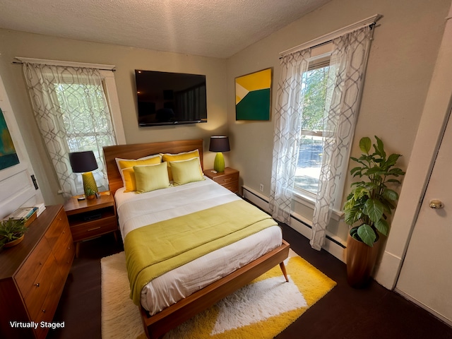 bedroom with a textured ceiling and baseboard heating