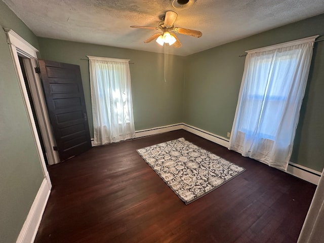 spare room featuring dark wood-style floors, a textured ceiling, and plenty of natural light