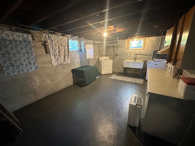 below grade area featuring separate washer and dryer and a sink