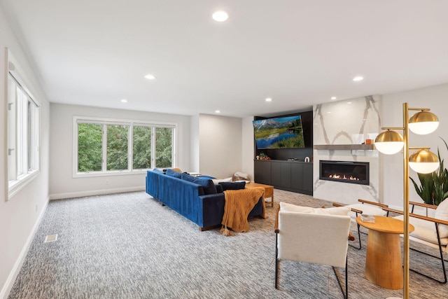 carpeted living room featuring a large fireplace